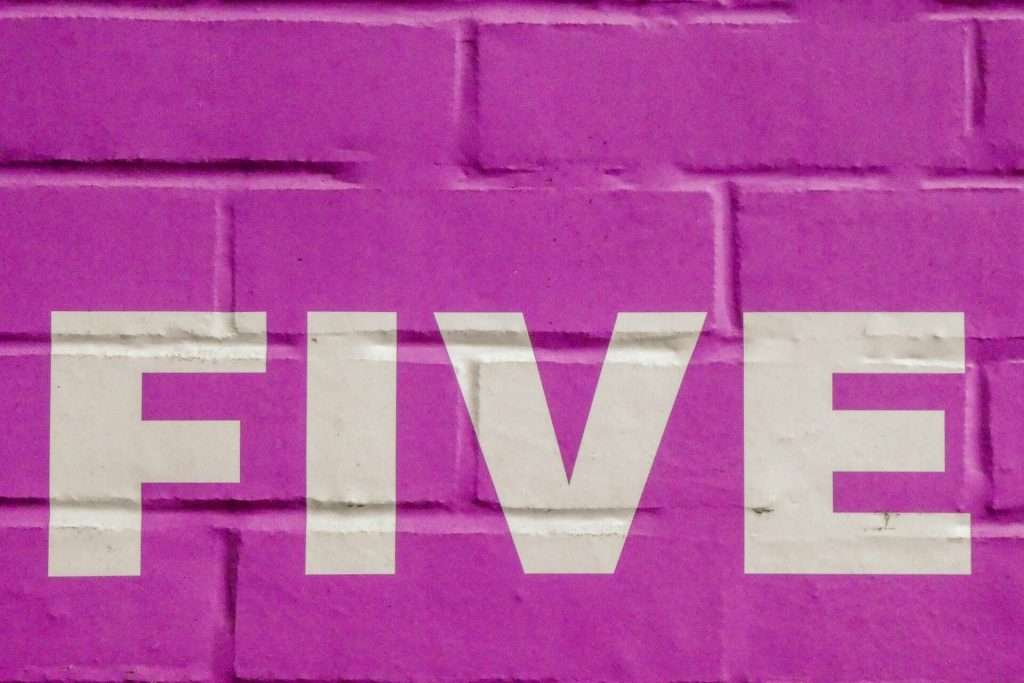 5 improve your marketing ROI - 5 written on purple brick wall