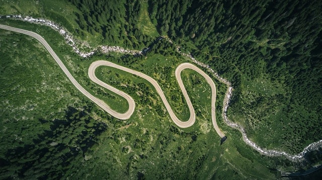 bird's eye view of a windy road in a green valley. Image for fy24 planning blog.